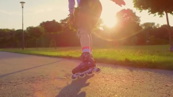 Visszapillantás felismerhetetlen fiatal nő görkorcsolyázás a parkban - Felvétel, videó