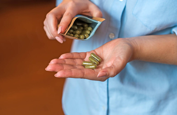 Concept of Eco pills, organic vitamins, medical and healthcare. Woman taking a pill - Photo, Image