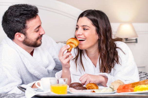 Пара веселится за завтраком в номере отеля
. - Фото, изображение