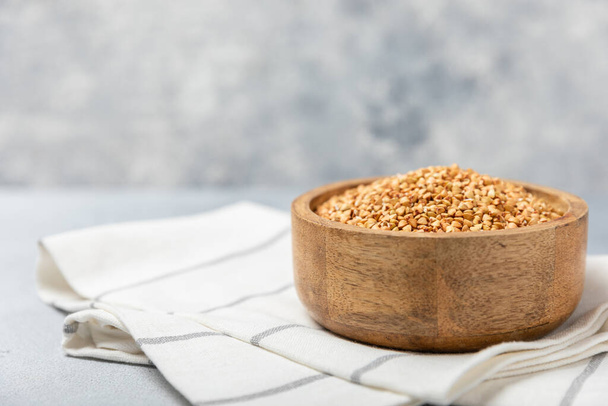 Green buckwheat in a bowl on a wooden kitchen table.Superfood.Raw buckwheat porridge.Healthy vegan food concept, eco products, diet. Copy space.Organic food.weight loss and proper nutrition. - Photo, Image