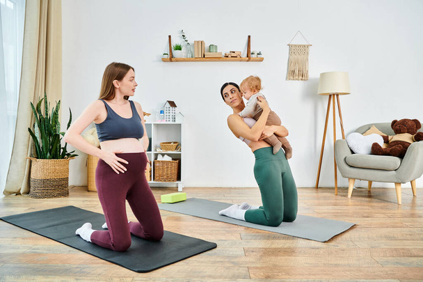 Молода мама витончено тримає дитину, стоячи на килимку для йоги під час сеансу батьківського курсу вдома. - Фото, зображення