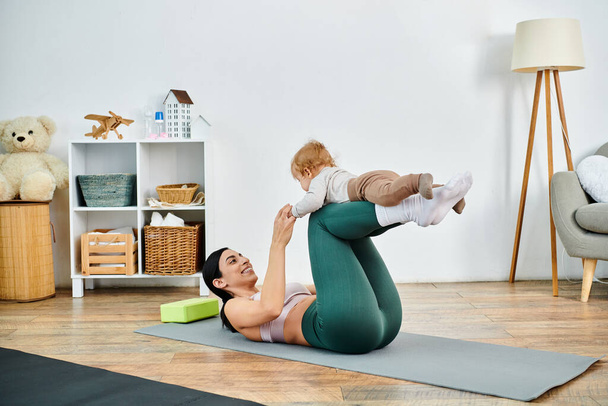 Une jeune et belle mère pratique gracieusement le yoga avec son bébé, guidée par un coach lors d'un cours de parents. - Photo, image