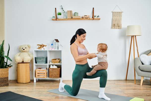 Eine junge, schöne Mutter praktiziert anmutig Yoga mit ihrem Baby, angeleitet von einem Trainer in einem pflegenden häuslichen Umfeld. - Foto, Bild