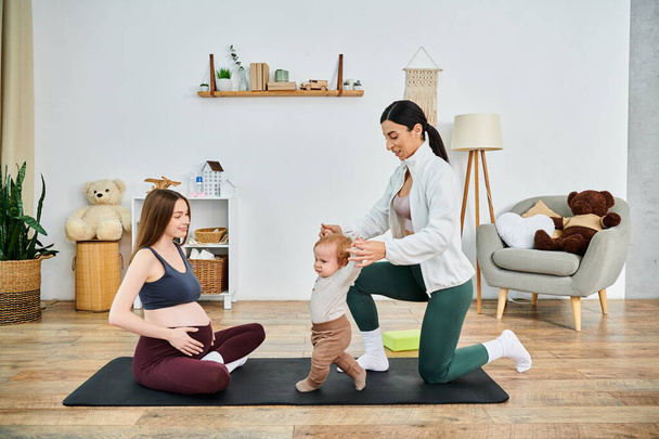 Egy fiatal, gyönyörű anya otthon gyakorolja a jógát a kisbabájával, az edzője vezetésével a szülői tanfolyamokról.. - Fotó, kép