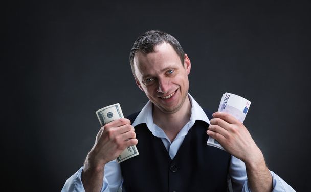 Cheerful businessman holds money - Foto, Imagen