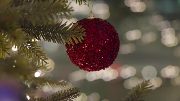 Vánoční stromeček zdobený míčky přes rozmazané noční světlo města na oslavě - Záběry, video