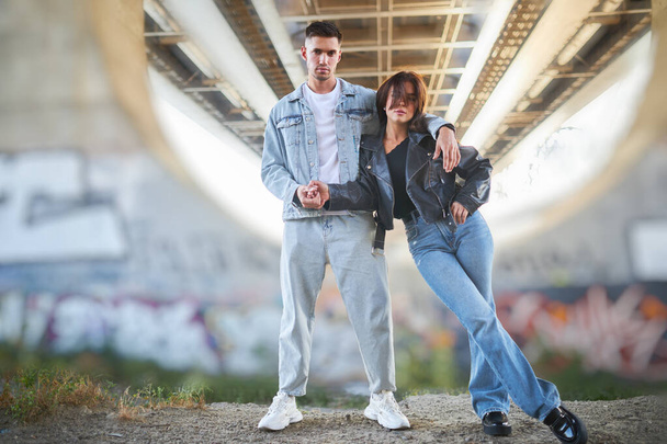 Stylischer junger Mann und junge Frau posieren auf der Straße, ein verliebtes Paar. - Foto, Bild