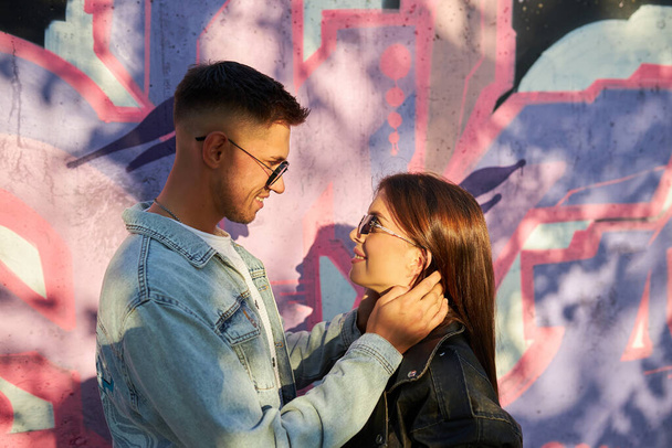 Stylischer junger Mann und junge Frau posieren auf der Straße, ein verliebtes Paar. - Foto, Bild