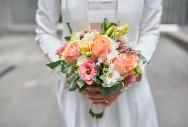 Pełne wdzięku ręce trzymając bukiet panny młodej, pokazując piękno kwiatów ślubnych. - Zdjęcie, obraz