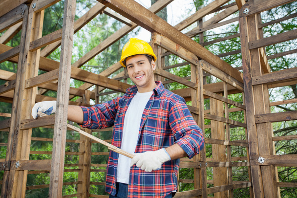 Happy Carpenter Holding Measure Tape At Construction Site - Foto, Imagem