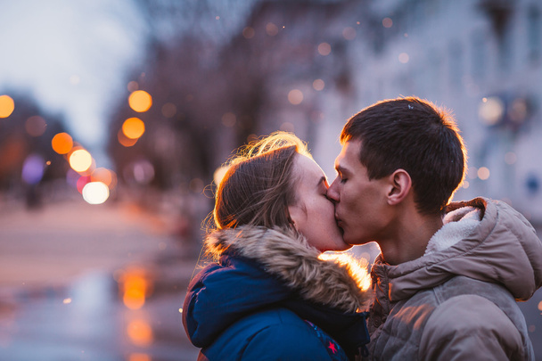 Portrait of young beautiful couple kissing in an autumn rainy day. - Foto, Imagen
