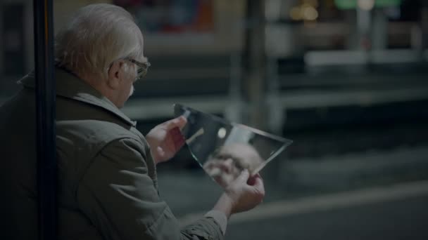 Szomorú, idős férfi, aki öregségi szegénységben szenved, mert magányos a vasútállomáson. - Felvétel, videó
