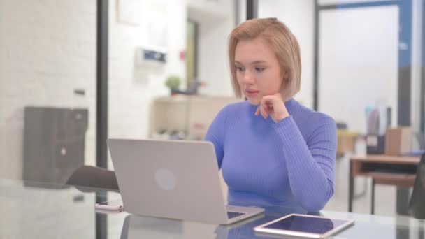 Pensive mladá žena sedí v kanceláři - Záběry, video