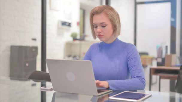 Nuori nainen työskentelee kannettavan tietokoneen toimistossa - Materiaali, video