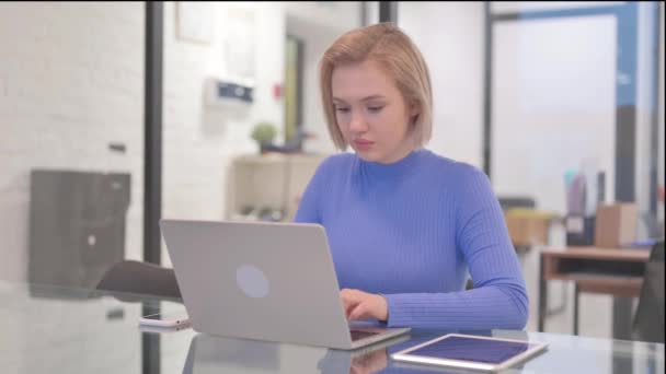 Młoda kobieta wskazując na aparat w biurze - Materiał filmowy, wideo