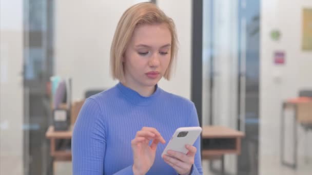 Πορτρέτο της νεαρής γυναίκας που χρησιμοποιεί το τηλέφωνο στο γραφείο - Πλάνα, βίντεο