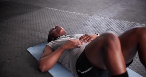 Tired, fitness and black man on the floor, gym and exercise with workout and sports with hobby. Exhausted, wellness center or African person relax after intense training or health goals with progress. - Footage, Video