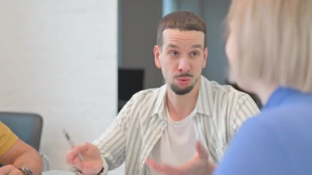 Gros plan d'un jeune homme créatif parlant avec ses coéquipiers - Séquence, vidéo