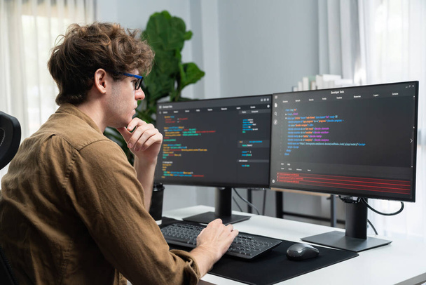 Pracujący programista IT ze stresującym przepracowany w tworzeniu oprogramowania online kodowania na ekranie komputera, myślący program dla najnowszej wersji aplikacji na stronie projektu w nowoczesnym biurze. Pędziwiatr. - Zdjęcie, obraz