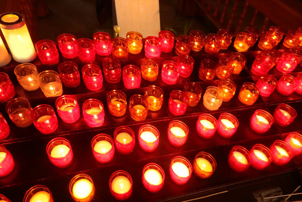 velas votivas acesas durante o rito religioso dentro do local de culto - Foto, Imagem