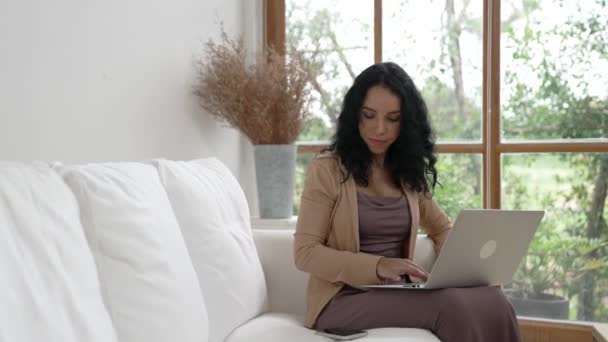 Telefonda konuşan Afro-Amerikalı bir kadın, internet üzerinde önemli bir iş için dizüstü bilgisayar kullanırken, aynı zamanda telesal yapıyor. Evde çalışan sekreter veya çevrimiçi içerik yazma. - Video, Çekim
