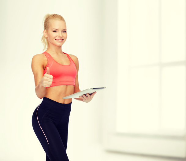 smiling sporty woman with tablet pc computer - Fotoğraf, Görsel