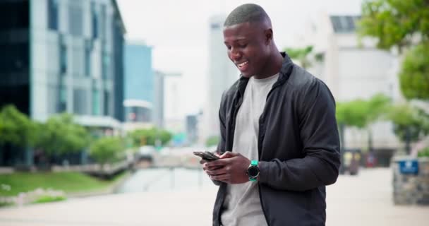 Teléfono, búsqueda y hombre negro feliz en una calle de la ciudad con las redes sociales, streaming o mensajes de texto al aire libre. Smartphone, viajes y africano persona masculina con aplicación para Internet, chat o comunicación de contacto. - Imágenes, Vídeo