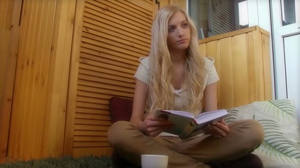 Woman drinking coffee and reading book - Footage, Video