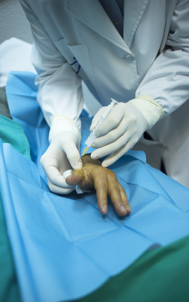 Médico cirujano inyectando paciente en clínica hospitalaria
 - Foto, Imagen