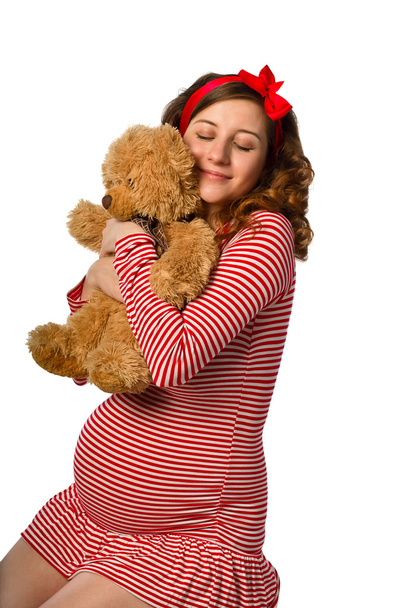 Hermosa chica embarazada abrazando un juguete
 - Foto, Imagen