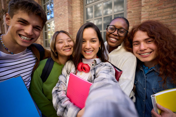 Selfie di un gruppo di studenti felici amici multirazziali divertirsi all'aperto al campus universitario. Diversi allegri giovani gioiosi guardando la fotocamera e sorridendo e ridendo insieme - Foto, immagini