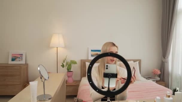 Молода жінка робить косметичний відео-контент для соціальних медіа. Блогер краси використовує камеру та світлове кільце, показуючи, як наносити вії аудиторії або послідовнику. Блайт - Кадри, відео