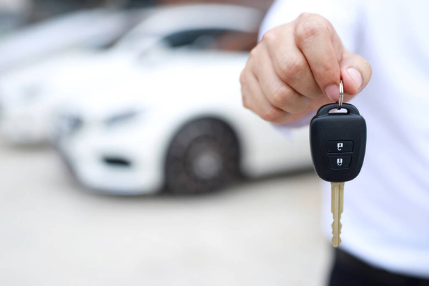 Car key, businessman handing exchange over give to the other man on showroom background. Seller dealer credit Interest payment or purchase by installment car concept. - Photo, Image