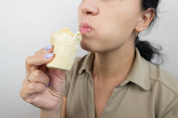 アイスクリームを食べる女性のクローズアップ. クロップされた写真. - 写真・画像