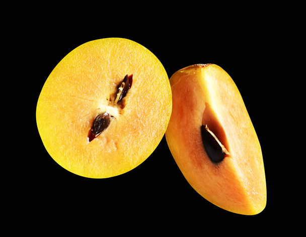Шматочок саподілли і шматок ізольовані без тіні з відсічним контуром на чорному фоні, здорові свіжі тропічні фрукти - Фото, зображення