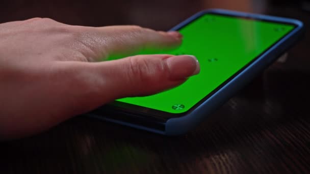 Femme utilise un smartphone avec un écran vert avec une clé chromatique. Parcourir les réseaux sociaux ou boutique en ligne - Internet, concept de communication en gros plan. - Séquence, vidéo