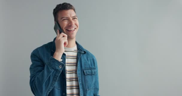 Man, phone call and laughing in studio for funny conversation and funny joke by gray background. Person, comic and happy for communication on cellphone, social and comedy for silly gossip in mock up. - Footage, Video