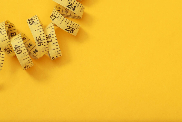 tape measure for obese people on a yellow background soft focus - Photo, Image