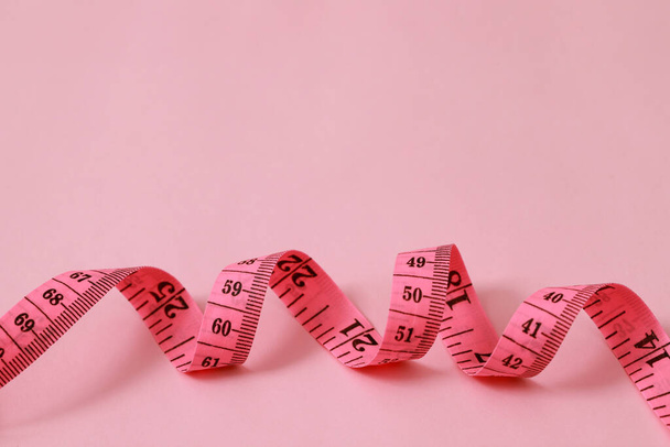 μέτρο ταινία για παχύσαρκους ανθρώπους σε ένα ροζ φόντο μαλακό εστίαση - Φωτογραφία, εικόνα