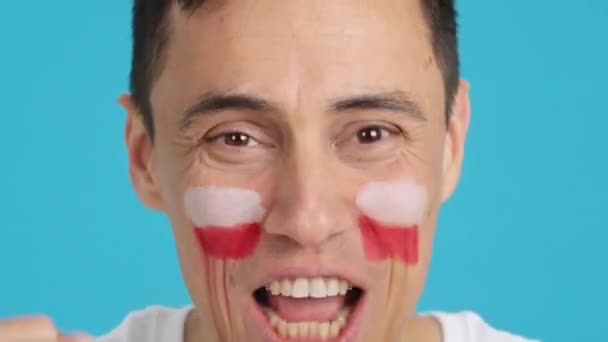 Video in studio met chroma van een close-up van een man met een Poolse vlag geschilderd op het gezicht ondersteunen polish team - Video