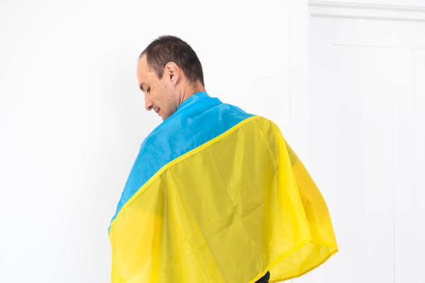 Joven feliz con bandera ucraniana sobre fondo blanco. Foto de alta calidad - Foto, imagen