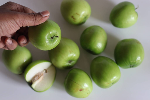 Ber apple o Juju Be. Immagine vibrante di Juju Be mela, in mostra la sua consistenza e il colore ricco, sia all'interno che all'esterno. Perfetto per la salute, la nutrizione e i disegni a tema frutta. Girato su sfondo bianco - Foto, immagini