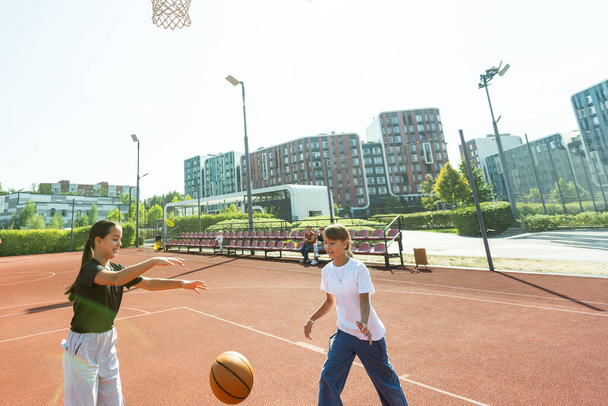 Açık şehir basketbol sahasında top oynayan genç kız sokak basketbolcusu. Yüksek kalite fotoğraf - Fotoğraf, Görsel