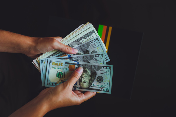Amerikkalaisia dollareita käsissä, naisia laskemassa rahaa
 - Valokuva, kuva