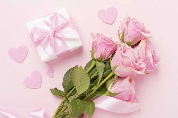 Pink roses with hearts and gift box on color background, top view. Valentines day concept - Photo, Image
