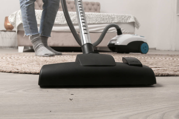 Huisvrouw stofzuigen van de kamer, huishoudelijk leven, appartement schoonmaak concept - Foto, afbeelding