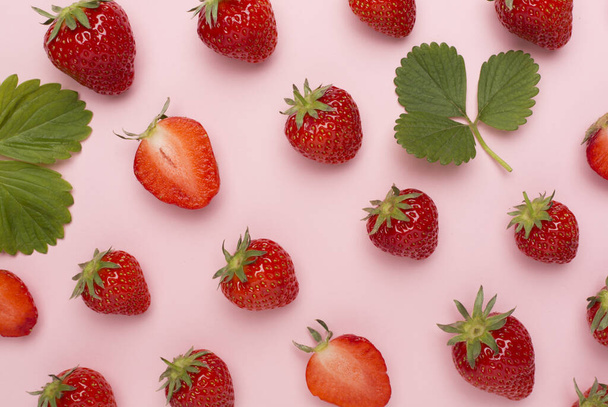 Erdbeeren mit Blättern auf farbigem Hintergrund, Ansicht von oben - Foto, Bild