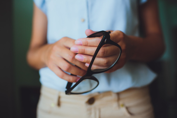 Main humaine femme tenant des lunettes
 - Photo, image