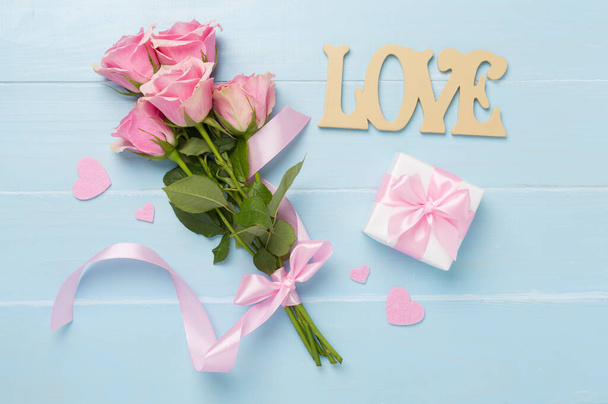 Růžové růže se srdcem a dárkovou krabicí na dřevěném pozadí, výhled shora. Valentines day concept - Fotografie, Obrázek