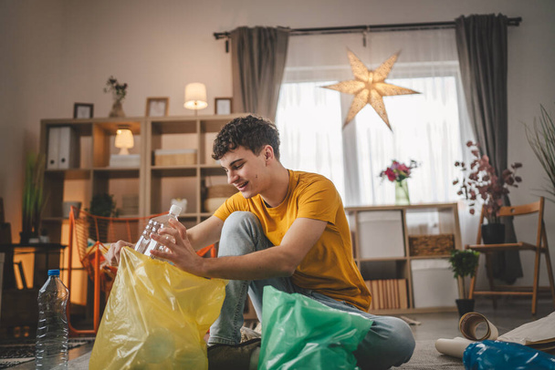 один человек молодой взрослый переработка на дому сорта отходов пластиковой бумаги и стекла - Фото, изображение